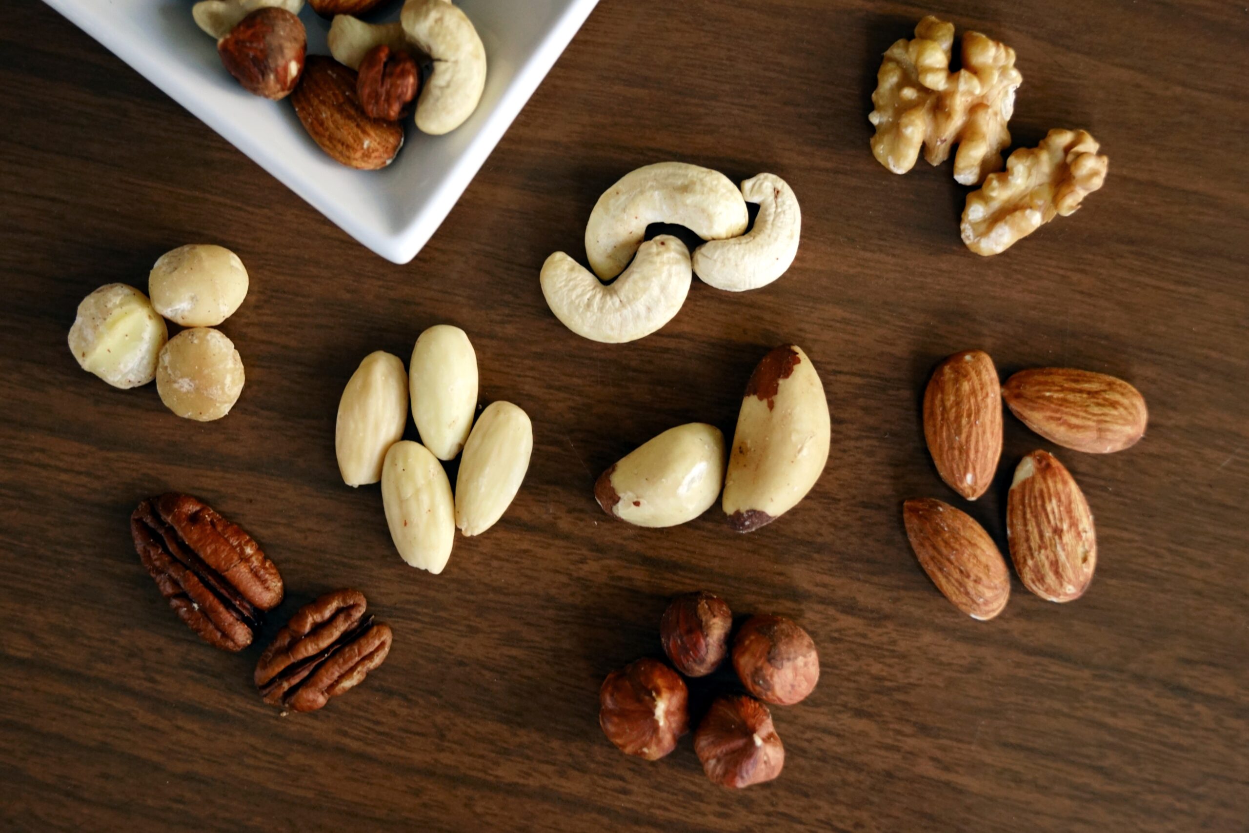 variety-of-brown-nuts-on-brown-wooden-panel-high-angle-photo-1295572